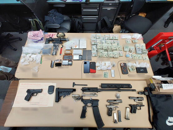 Image of firearms, currency, and narcotics seized during arrest